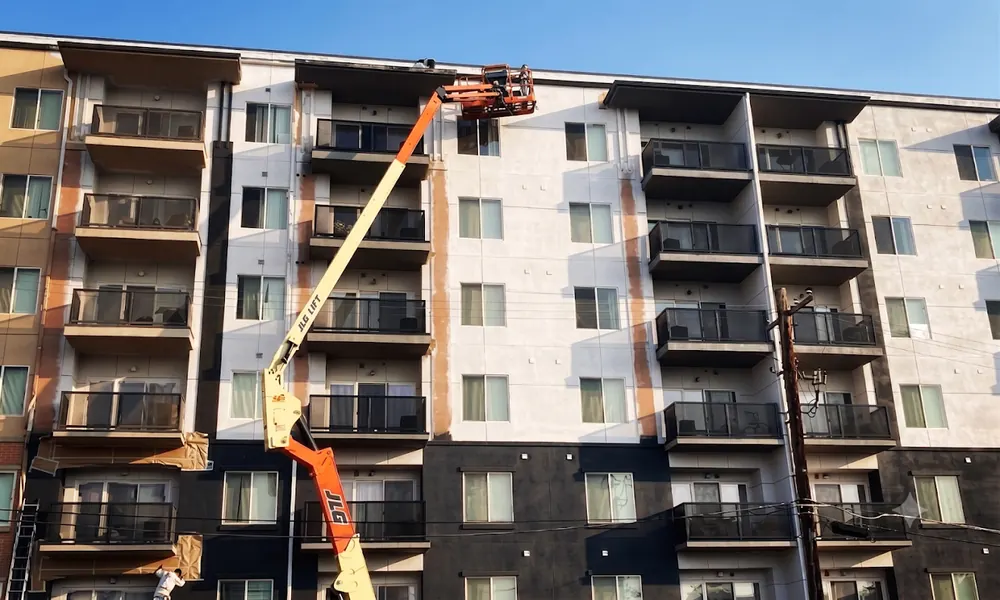 Multi family apartment building exterior painting from a lift
