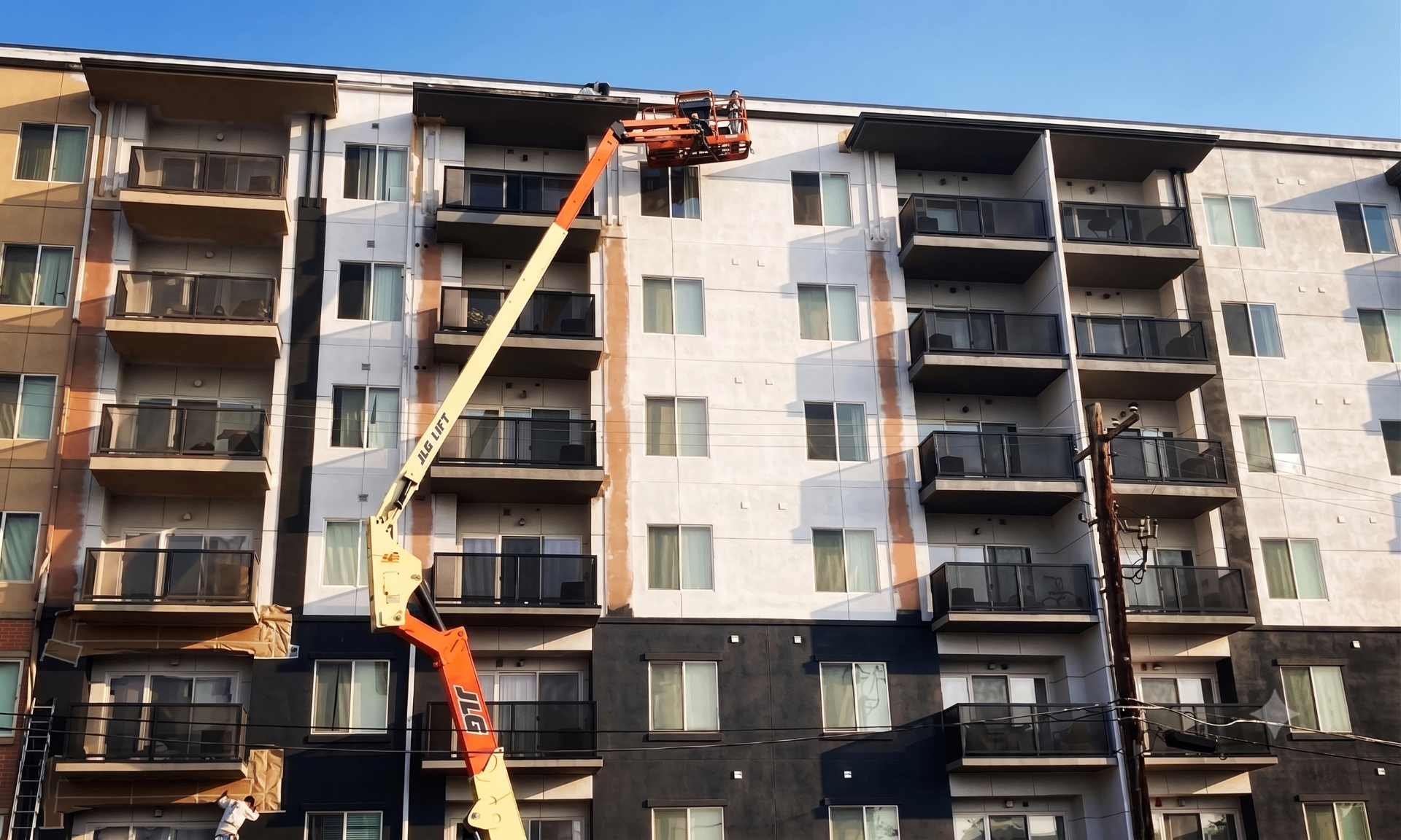 Color Drop crew on a JLG boom lift painting a multi-story Las Vegas apartment building